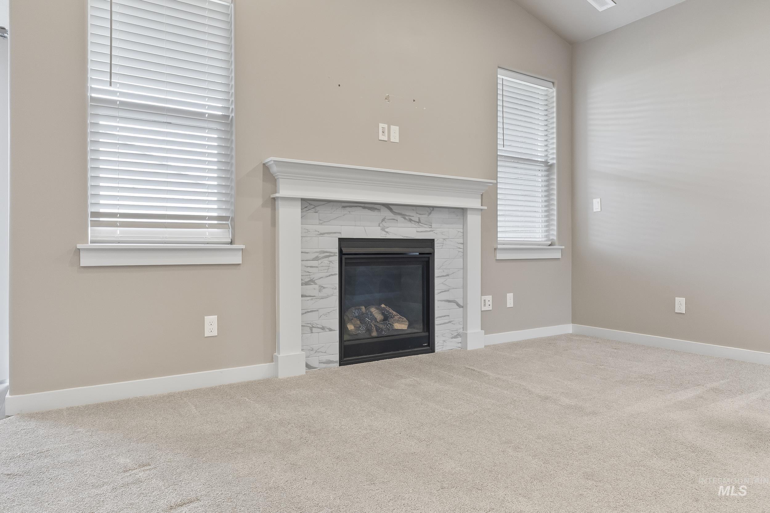 10308 West Trident Ridge Drive Star, ID 83669 - Photo 10 of 42 Unfurnished living room with carpet, a fireplace, and vaulted ceiling