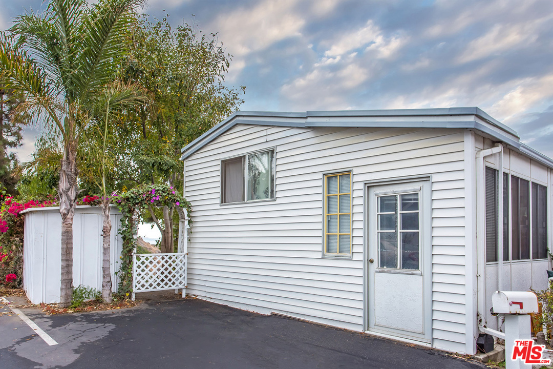 36 Copra Lane Pacific Palisades, CA 90272 - Photo 2 of 31 a view of a white house with large windows and a small yard