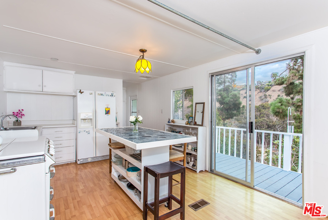 36 Copra Lane Pacific Palisades, CA 90272 - Photo 8 of 31 a kitchen with a wooden cabinets and white appliances