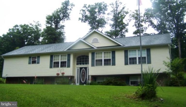 225 Barstow Road Prince Frederick, MD 20678 - Photo 1 of 10 a view of a white house next to a yard with plants and trees