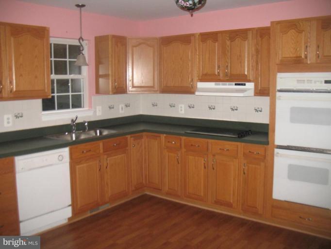 225 Barstow Road Prince Frederick, MD 20678 - Photo 3 of 10 a kitchen with granite countertop wooden cabinets and a sink