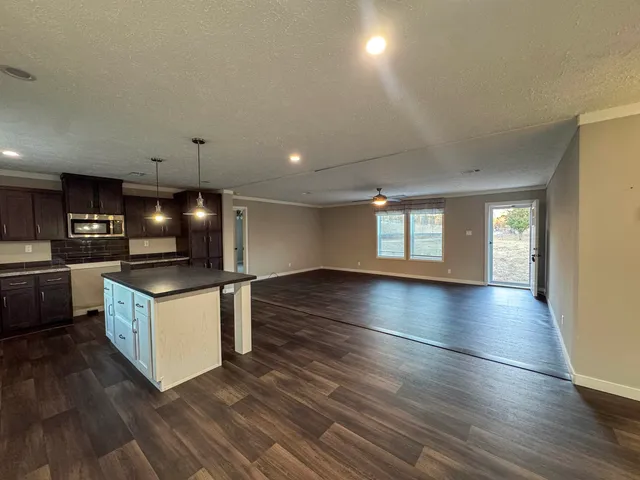 a kitchen with granite countertop a stove and a wooden floors