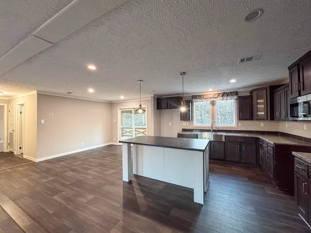 a kitchen with a sink cabinets and wooden floor