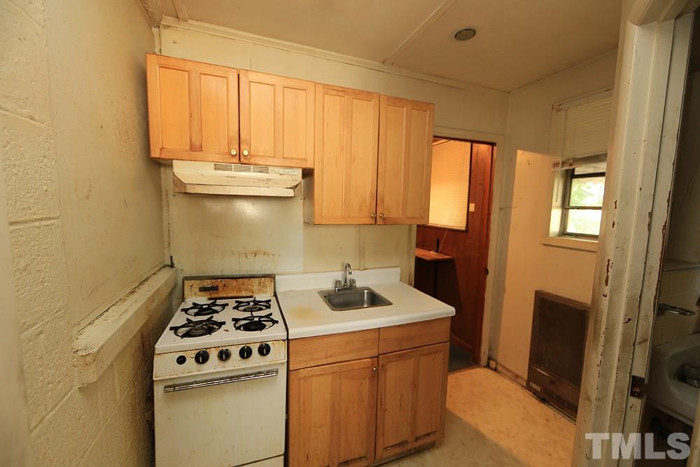 206 South Pettigrew Street Raleigh, NC 27610 - Photo 11 of 13 a kitchen with a stove a sink and a microwave