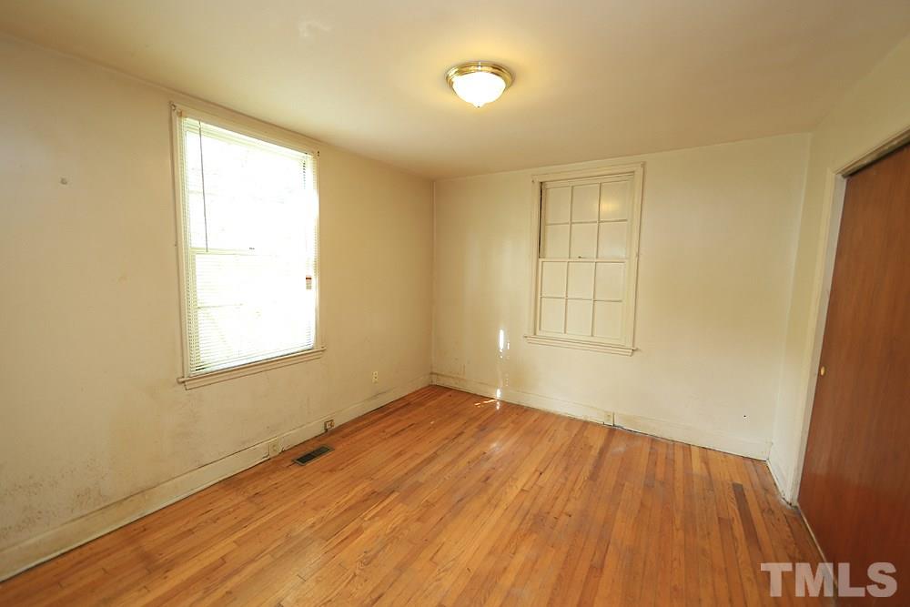 206 South Pettigrew Street Raleigh, NC 27610 - Photo 8 of 13 an empty room with wooden floor and windows