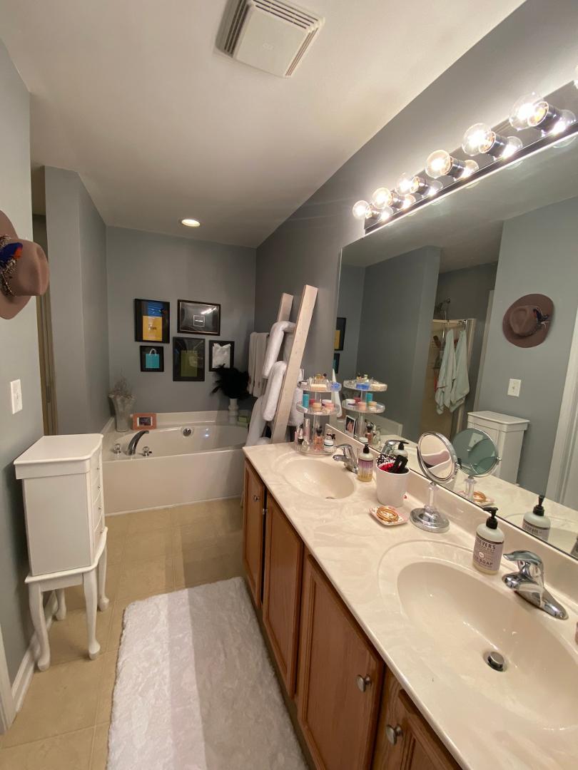4646 Altha Street Raleigh, NC 27606 - Photo 13 of 23 a large bathroom with a double vanity sink a mirror and a bathtub