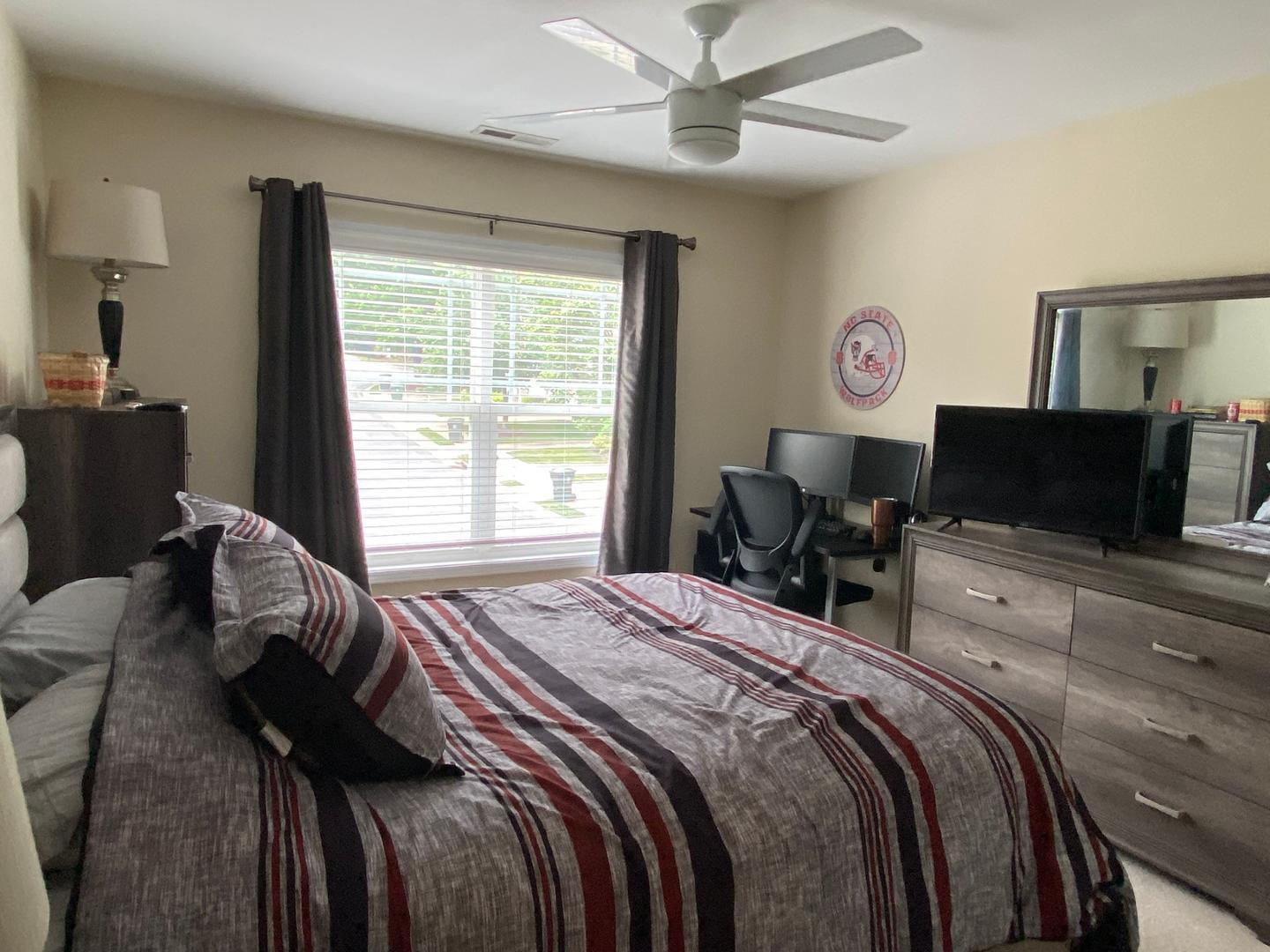 4646 Altha Street Raleigh, NC 27606 - Photo 17 of 23 a bedroom with a bed and a television