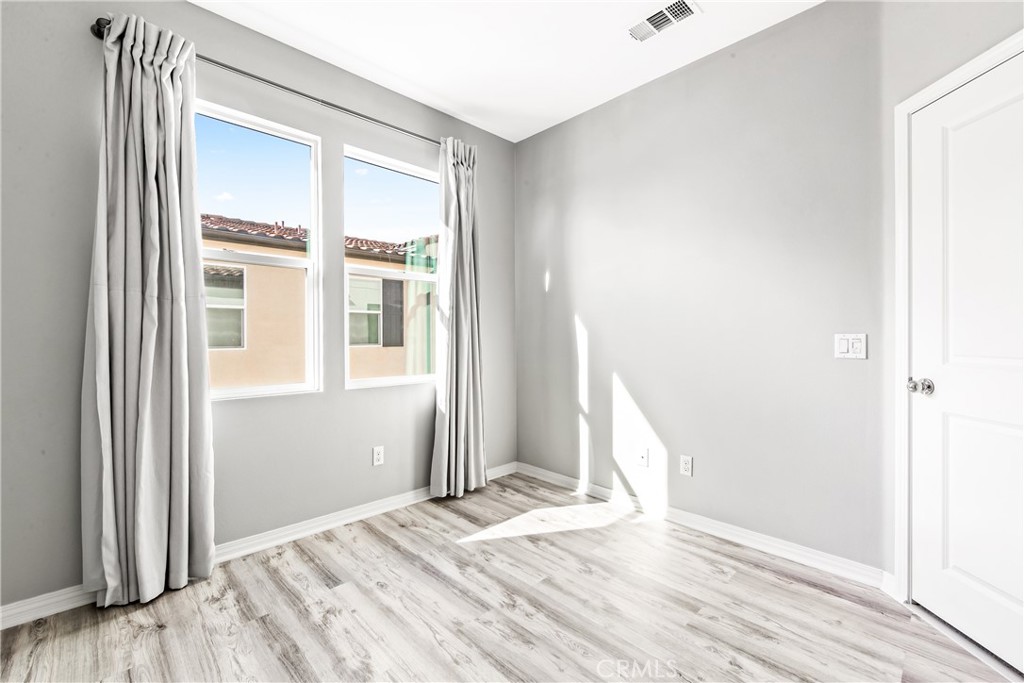 6331 Pacific Way Westminster, CA 92683 - Photo 24 of 38 a view of a bedroom with wooden floor and windows
