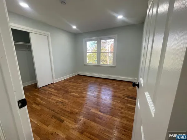 a view of empty room with wooden floor