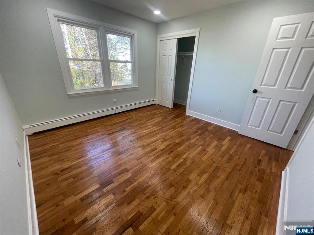 85 Grove Street, Unit 2 South Hackensack, NJ 07606 - Photo 7 of 8 a view of an empty room with wooden floor and a window
