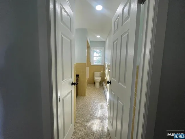 a view of a hallway with a livingroom and a chair