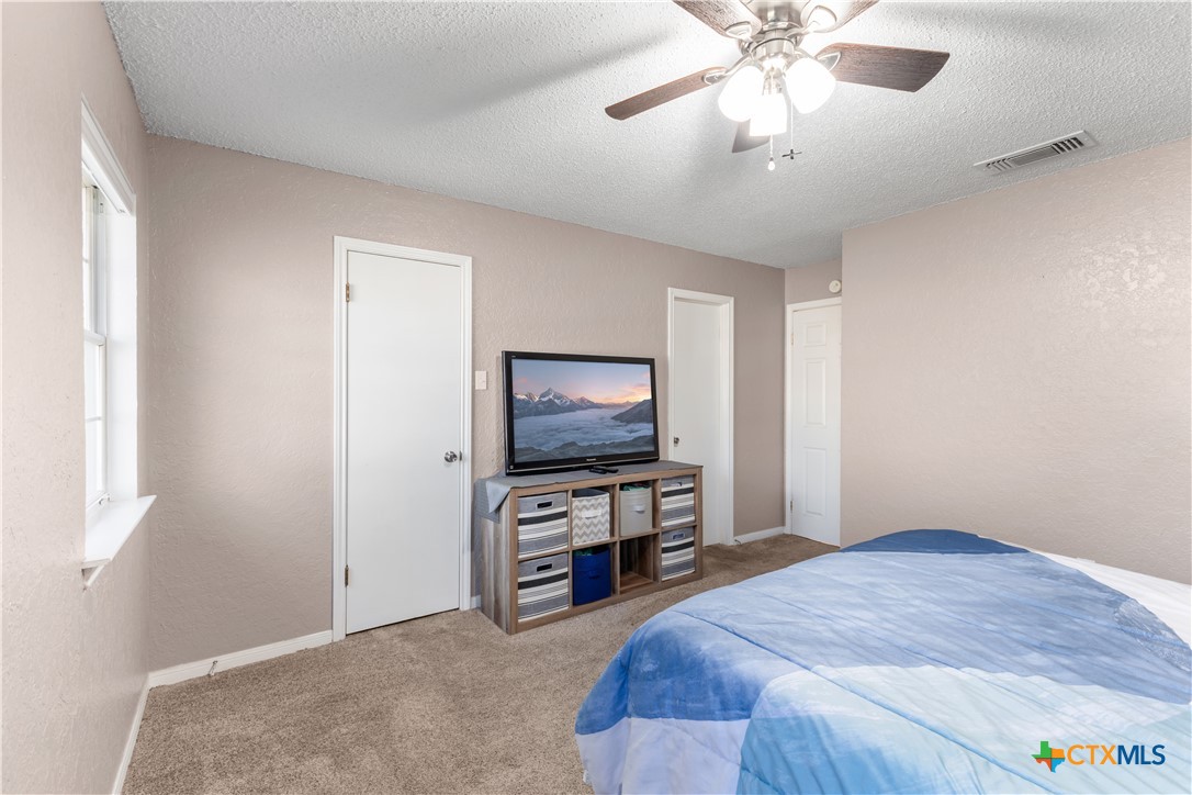 144 Jordan Loop Nolanville, TX 76559 - Photo 2 of 20 a bedroom with furniture and a flat screen tv