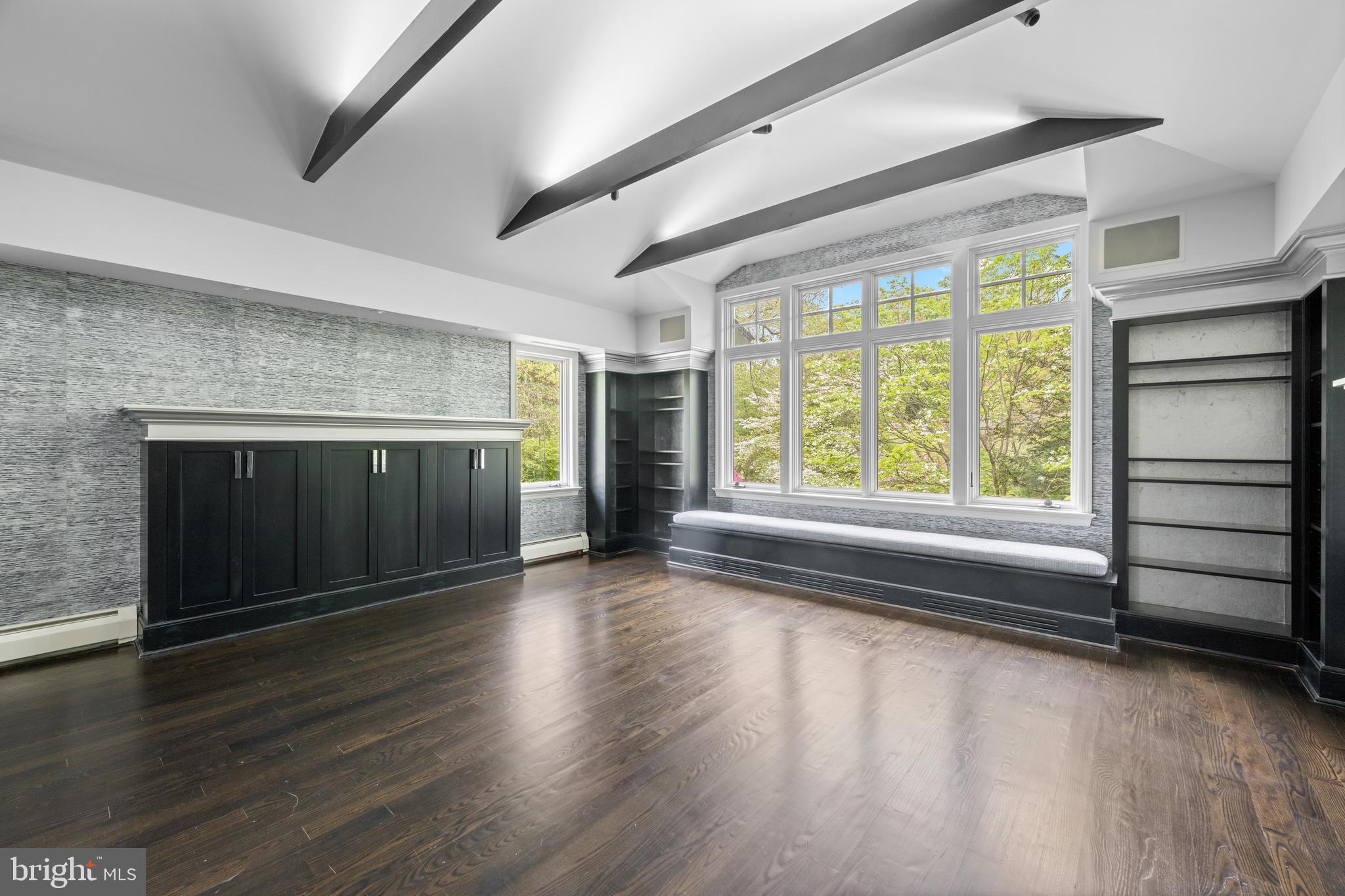 850 Lesley Road Villanova, PA 19085 - Photo 25 of 37 an empty room with wooden floor fireplace and windows