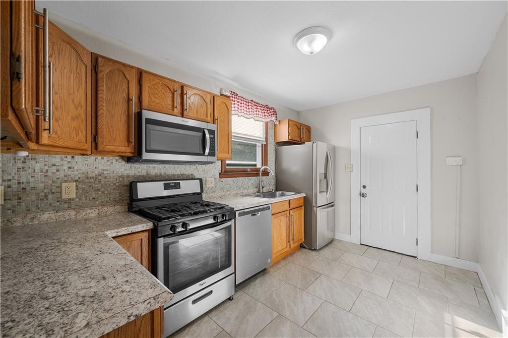 920 Watson Street Coraopolis, PA 15108 - Photo 14 of 36 a kitchen with stainless steel appliances granite countertop a stove a sink and a microwave