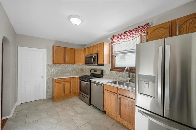 a kitchen with stainless steel appliances granite countertop a refrigerator sink and stove