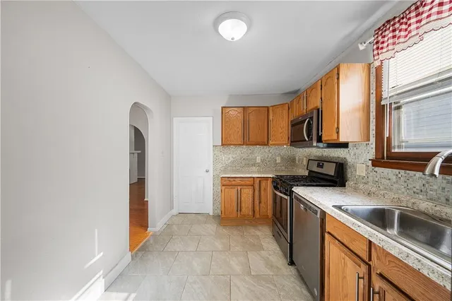 a kitchen with stainless steel appliances granite countertop a stove a sink and a refrigerator