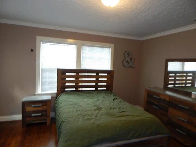 a bed sitting in a bedroom next to a window