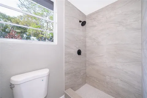 a bathroom with a toilet and a shower