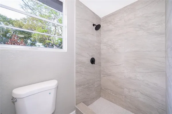 a bathroom with a toilet and a shower