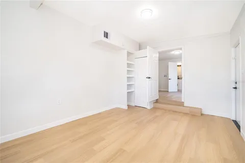 a view of a big room with closet and wooden floor