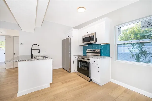 a kitchen with a sink stove and refrigerator