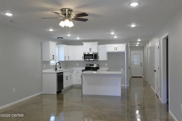 a kitchen with stainless steel appliances granite countertop a sink a stove and a refrigerator