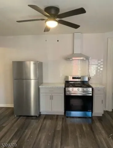a kitchen with stainless steel appliances a stove a refrigerator and a chandelier