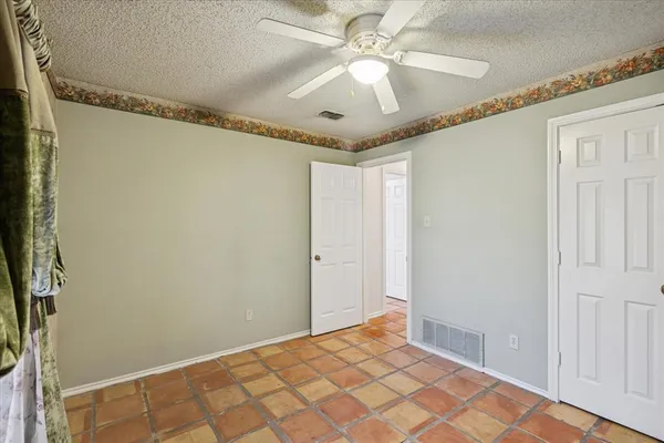 a view of a livingroom with a chandelier fan and wooden floor