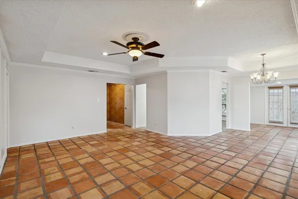 a view of a big room with a chandelier fan and windows