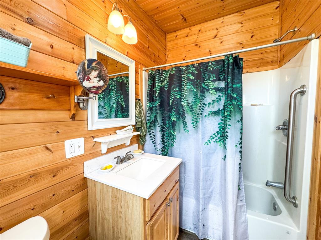 1209 Taylor Avenue Rule, TX 79547 - Photo 11 of 40 a bathroom with a sink and mirror with bathtub