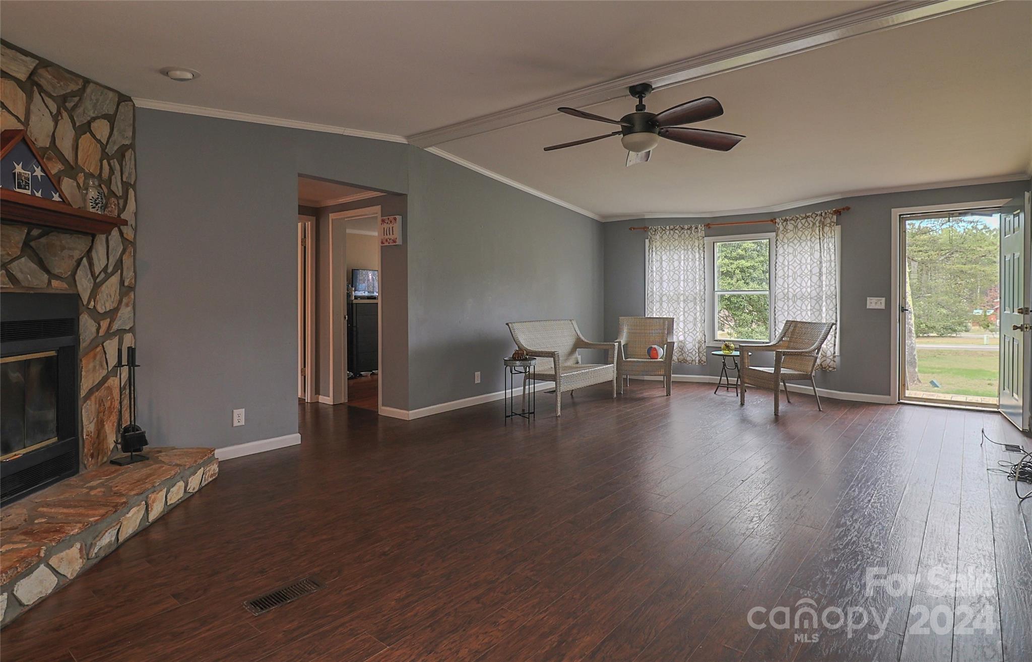 2338 Whiteside Road Mill Spring, NC 28756 - Photo 18 of 28 a view of a livingroom with wooden floor and a ceiling fan