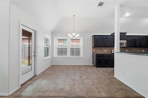 a kitchen with granite countertop a refrigerator and a stove top oven