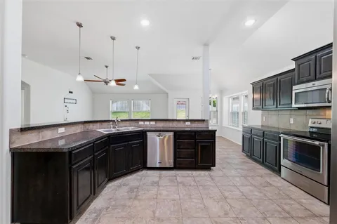 a kitchen with stainless steel appliances granite countertop a stove and a sink
