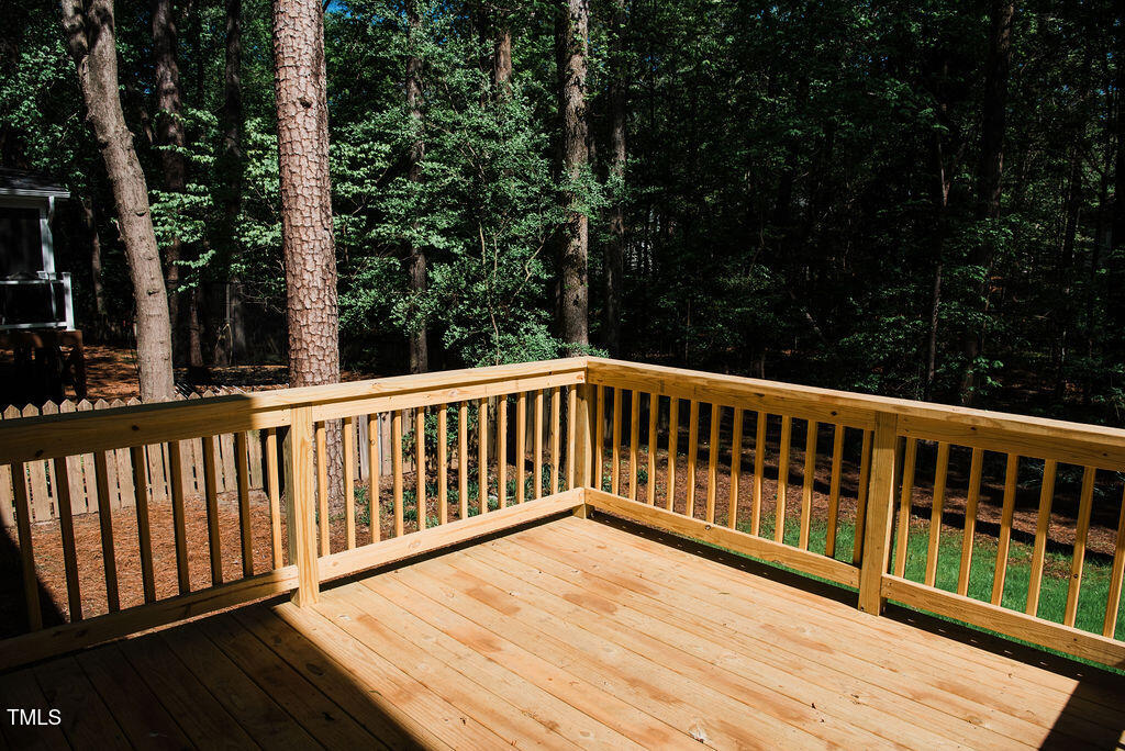 1326 Apache Lane Apex, NC 27502 - Photo 23 of 36 a balcony with wooden floor and trees in the back