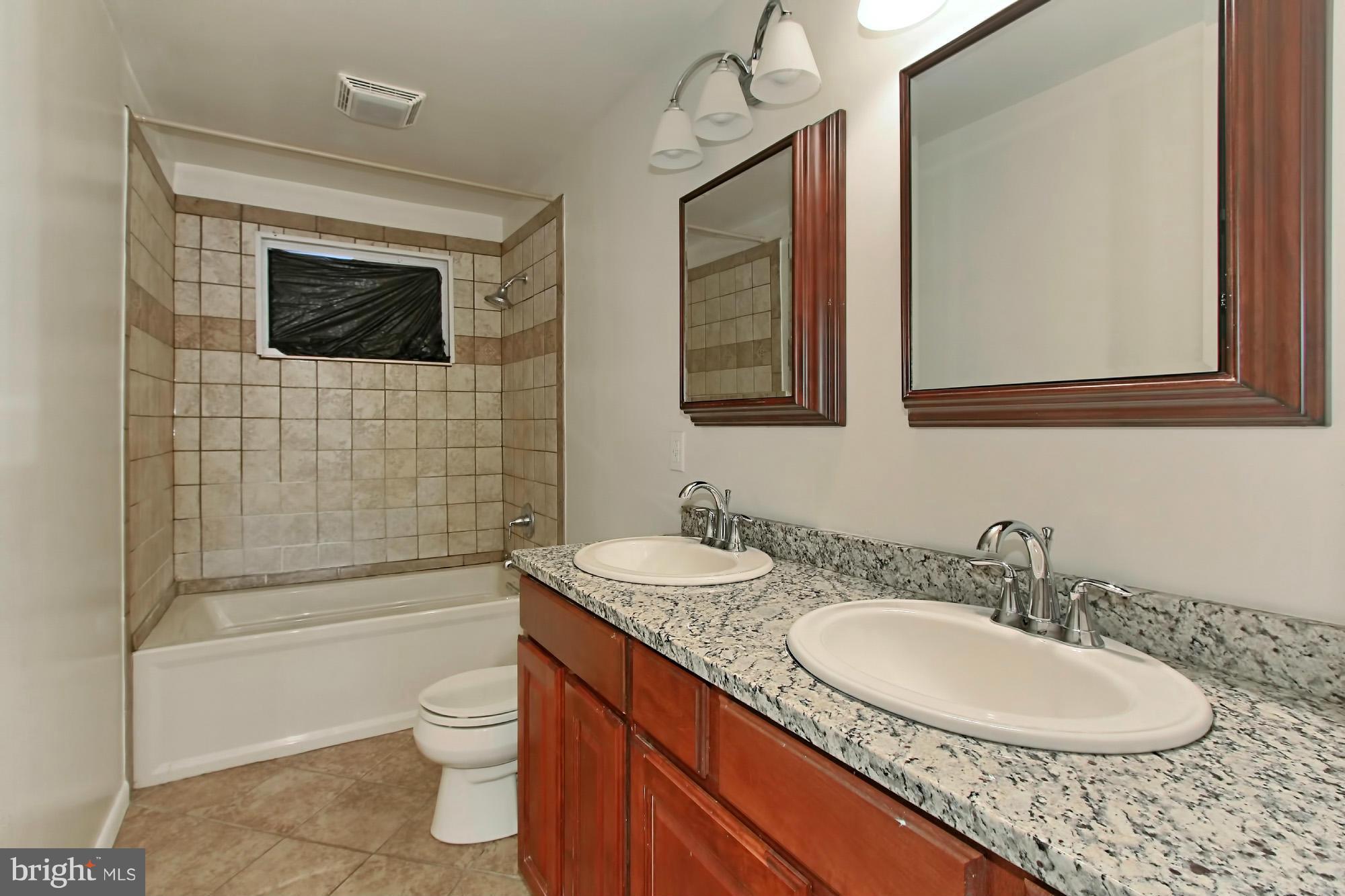 8126 Imperial Drive, Unit 5H Laurel, MD 20708 - Photo 21 of 30 a bathroom with a granite countertop sink a toilet a mirror and shower