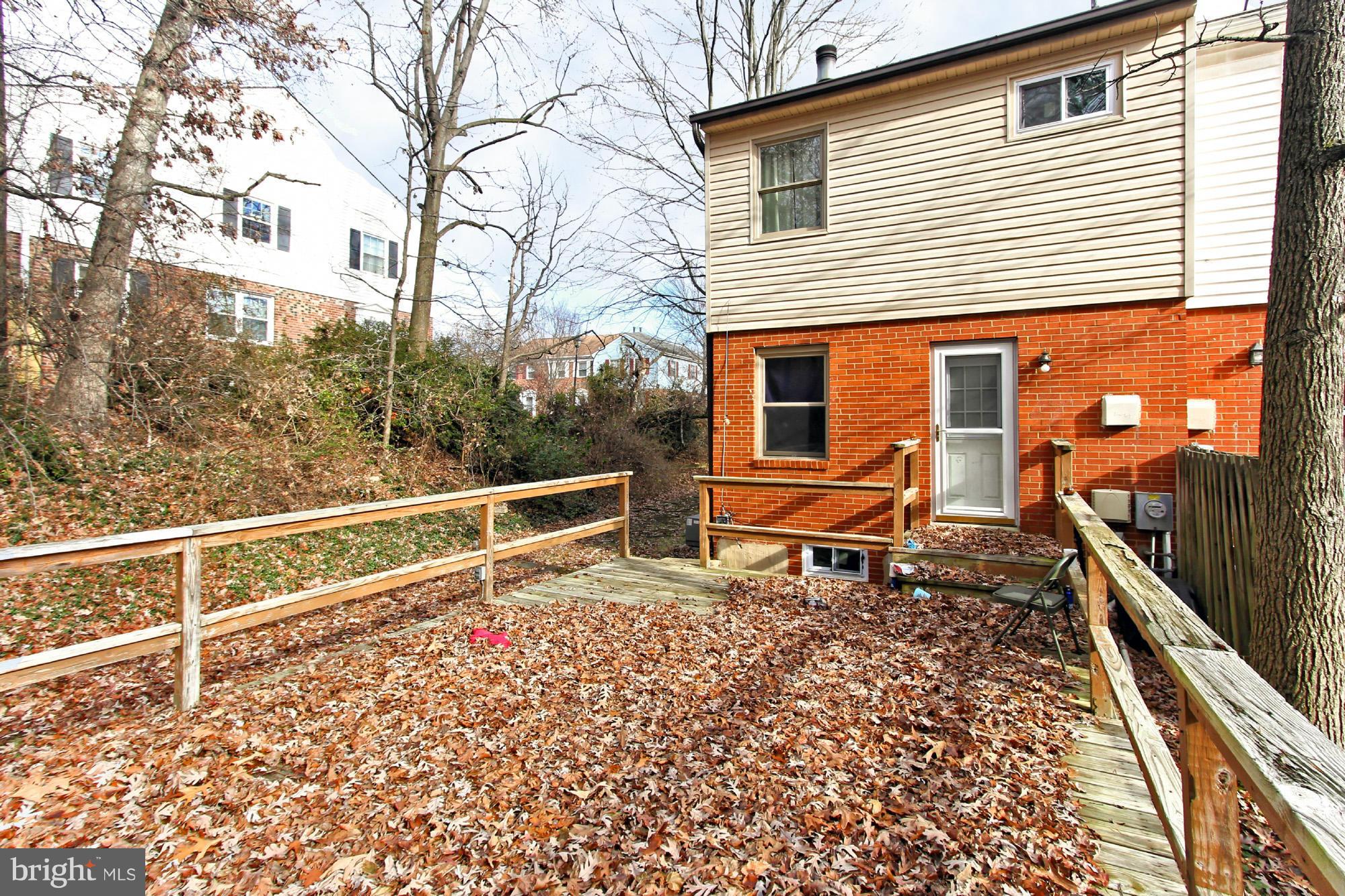 8126 Imperial Drive, Unit 5H Laurel, MD 20708 - Photo 26 of 30 a backyard of a house with wooden fence and a bench