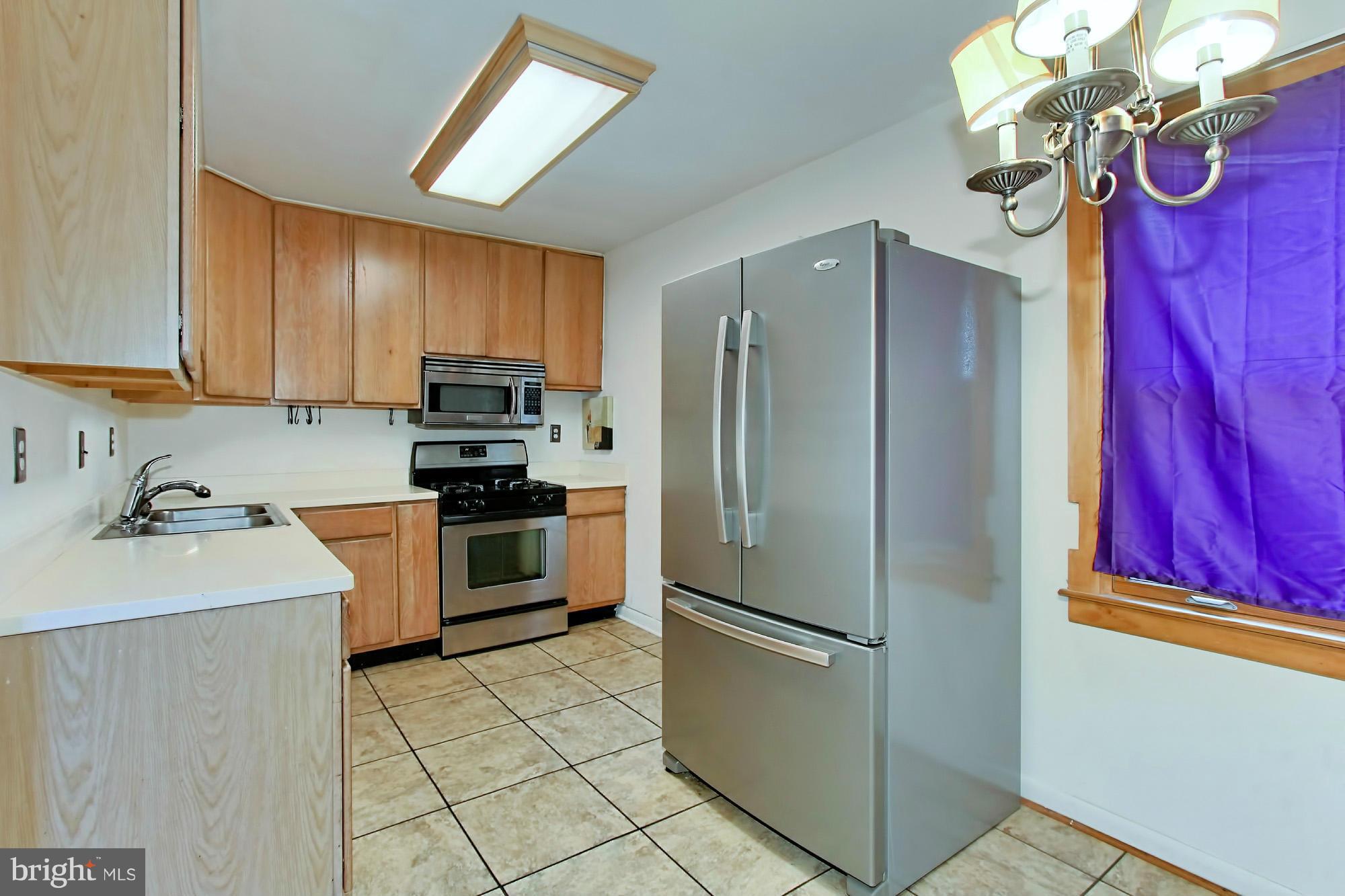 8126 Imperial Drive, Unit 5H Laurel, MD 20708 - Photo 8 of 30 a kitchen with stainless steel appliances granite countertop a refrigerator sink and stove
