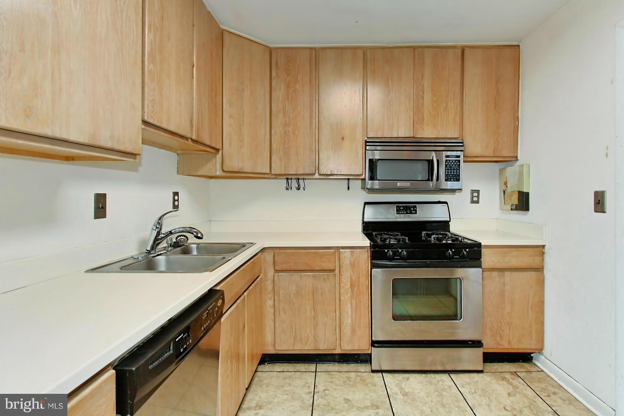 8126 Imperial Drive, Unit 5H Laurel, MD 20708 - Photo 9 of 30 a kitchen with a stove a sink and cabinets