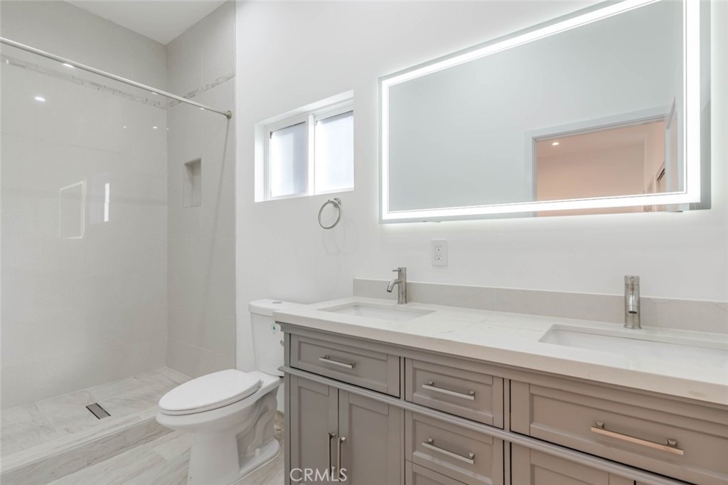 6852 1/2 Ranchito Avenue Van Nuys, CA 91405 - Photo 12 of 17 a bathroom with a sink a toilet and a mirror