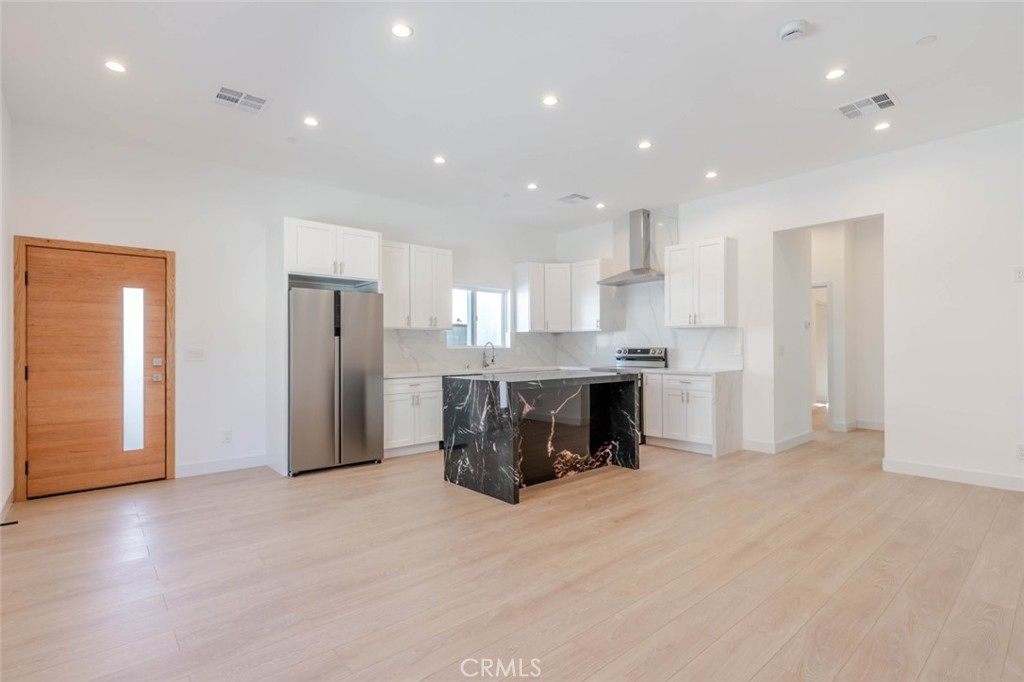 6852 1/2 Ranchito Avenue Van Nuys, CA 91405 - Photo 4 of 17 a kitchen with stainless steel appliances kitchen island granite countertop a refrigerator and a sink