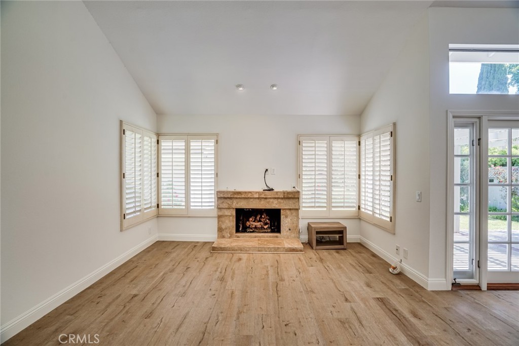 49 East Yale Loop, Unit 26 Irvine, CA 92604 - Photo 8 of 63 an empty room with fireplace wooden floor and windows