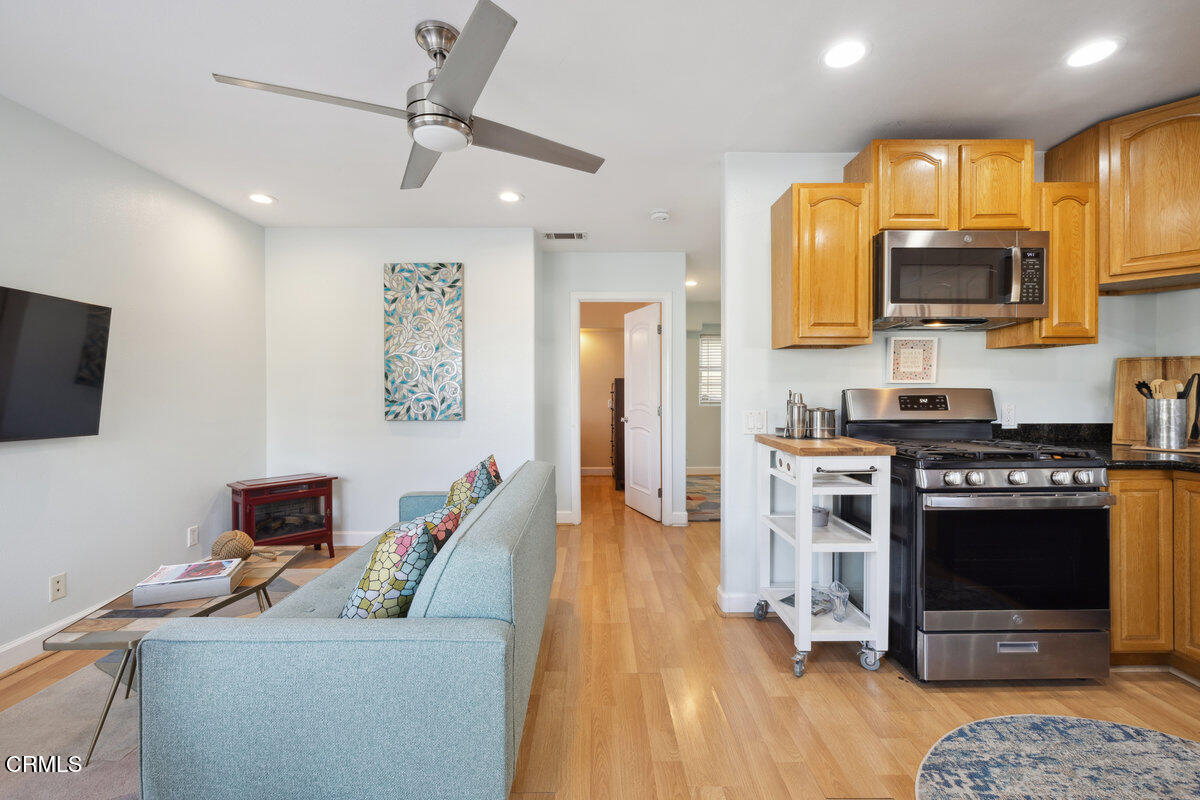 3701 Sunset Lane Oxnard, CA 93035 - Photo 13 of 54 a kitchen with stainless steel appliances kitchen island granite countertop a stove top oven a sink a dining table and chairs with wooden floor