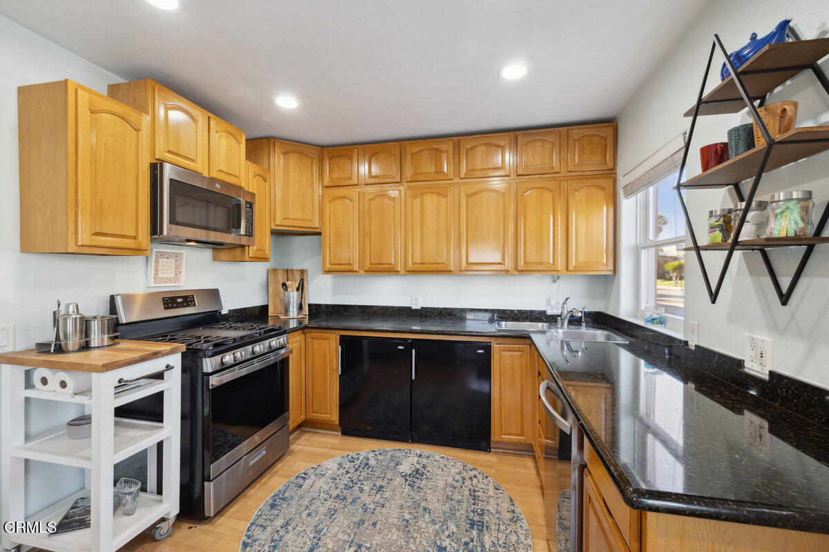 3701 Sunset Lane Oxnard, CA 93035 - Photo 9 of 54 a kitchen with stainless steel appliances granite countertop a stove a sink and a microwave