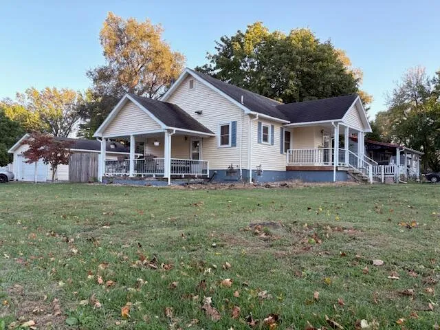a front view of a house with a garden and trees