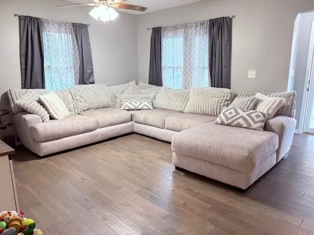 a living room with couches and a large mirror with wooden floor