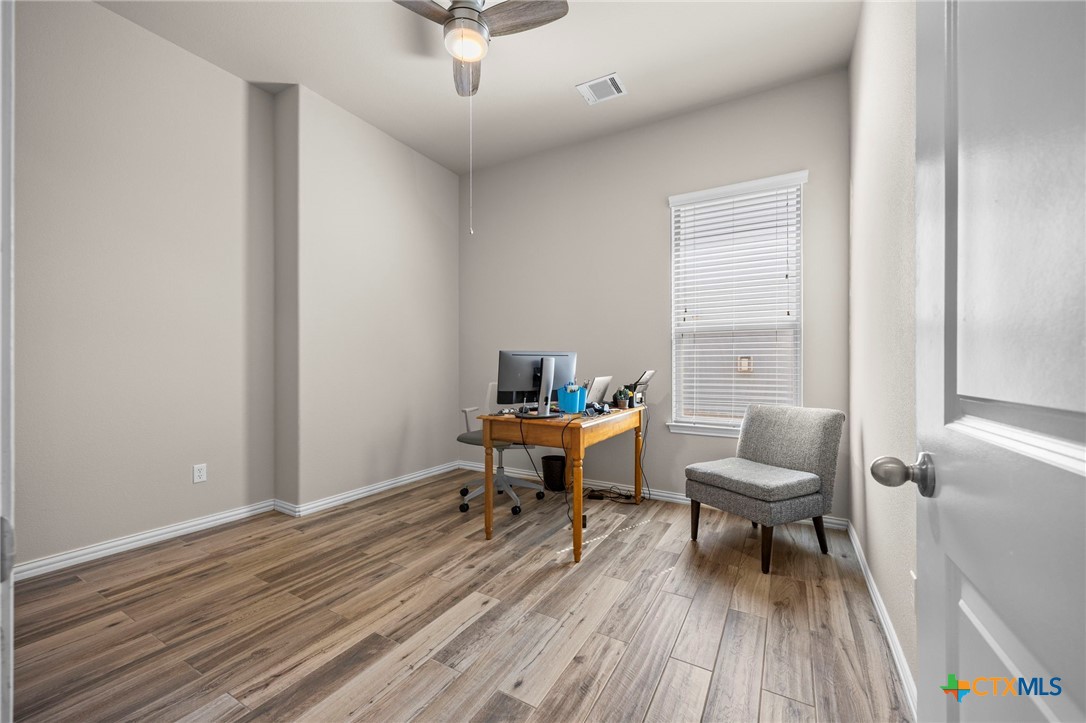 1205 Winding Way Drive Georgetown, TX 78628 - Photo 11 of 39 Bedroom with ceiling fan, vinyl flooring, and large window for natural light.
