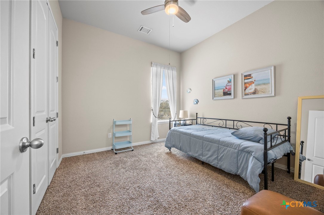 1205 Winding Way Drive Georgetown, TX 78628 - Photo 14 of 39 Secondary bedroom with ceiling fan, carpet, and window for natural light.