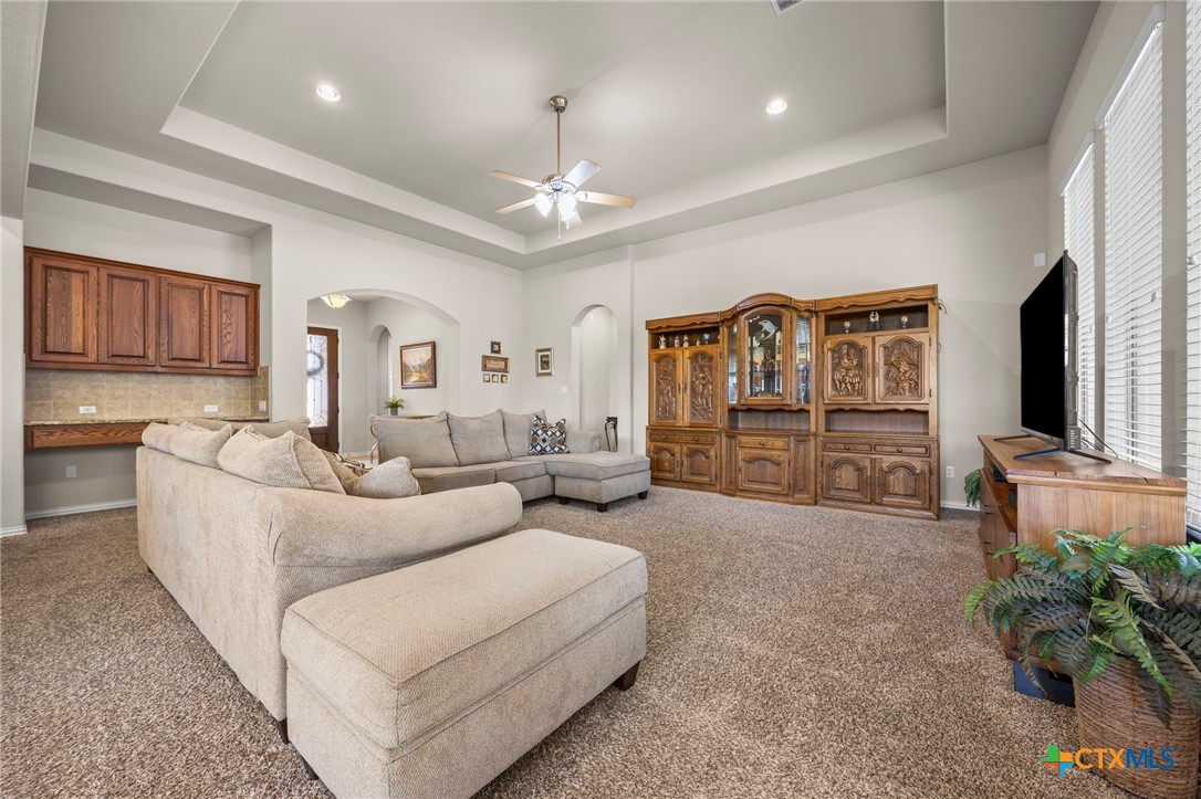 1205 Winding Way Drive Georgetown, TX 78628 - Photo 21 of 39 Another view of the living room with tray ceiling and built ins with desk on one side.