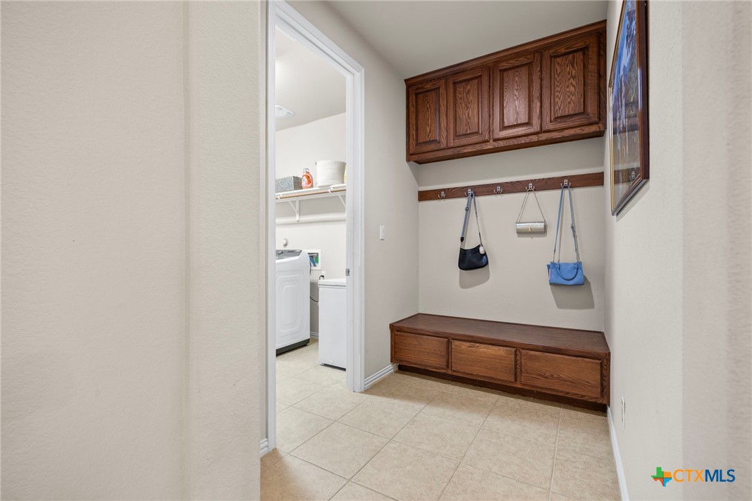 1205 Winding Way Drive Georgetown, TX 78628 - Photo 8 of 39 The mudroom has cabinets for storage and leads to the laundry room with washer and dryer.