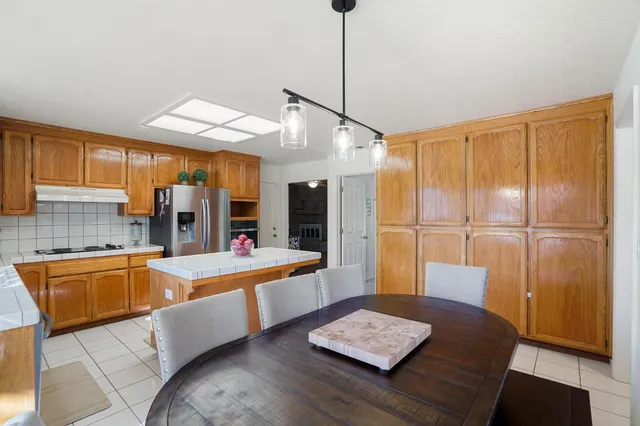 a kitchen with granite countertop a sink refrigerator and cabinets